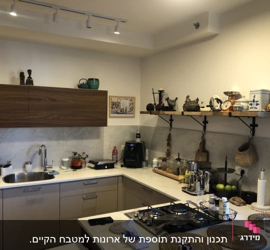 מטבח מודרני עם ארונות, כיור וכלי מטבח על המדפים